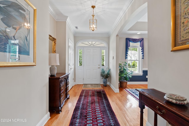 foyer entrance featuring crown molding and light hardwood / wood-style flooring