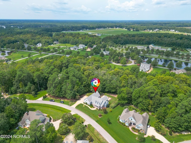 birds eye view of property with a wooded view and a water view