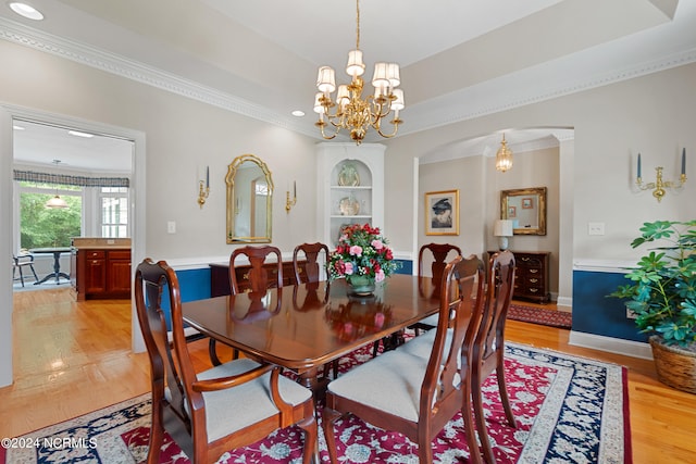 dining room with crown molding, light hardwood / wood-style flooring, and a notable chandelier