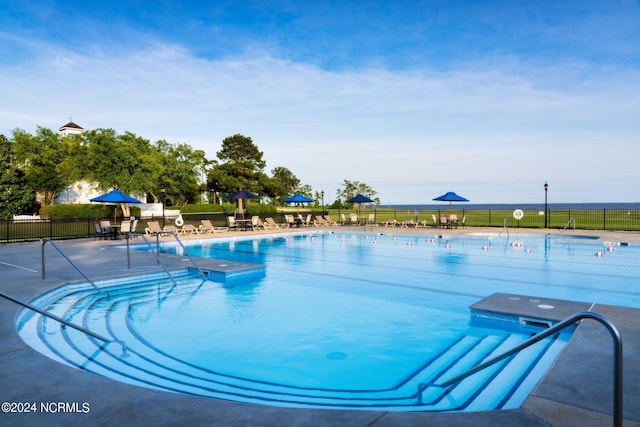 community pool with fence and a patio area