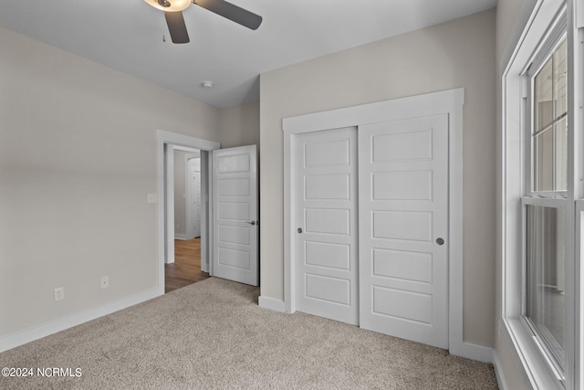 unfurnished bedroom featuring ceiling fan, carpet flooring, and a closet