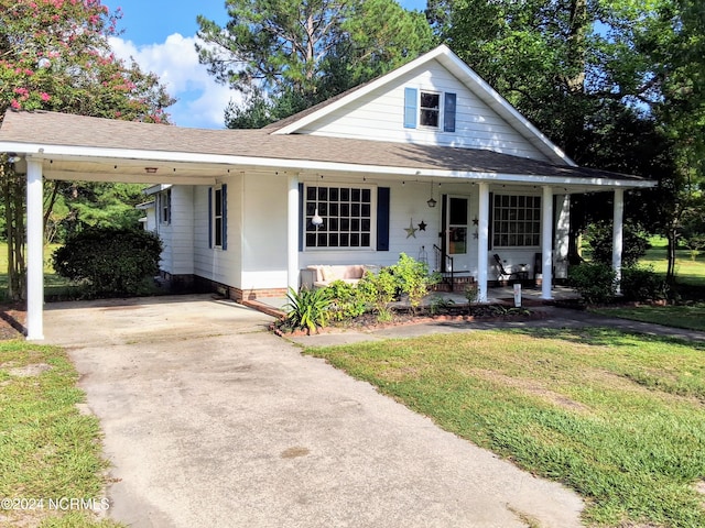 view of front of home with a front lawn, covered porch, and a carport