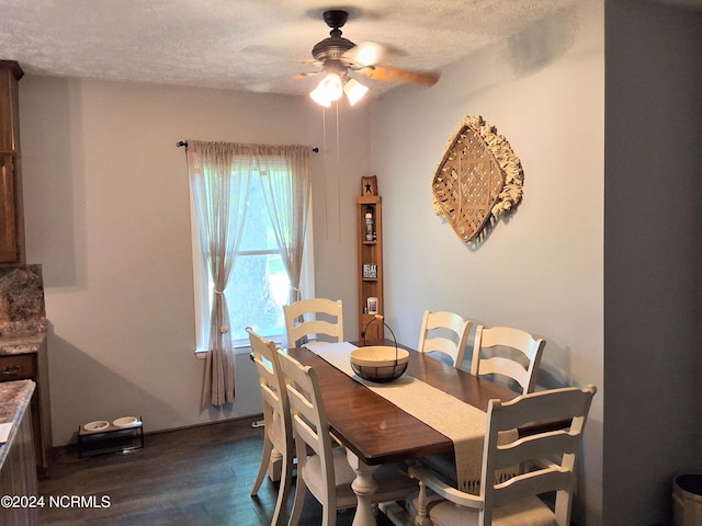 dining space featuring dark wood-style floors, a textured ceiling, and a ceiling fan