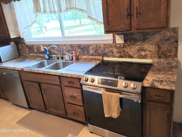 kitchen with a healthy amount of sunlight, decorative backsplash, stainless steel appliances, and a sink