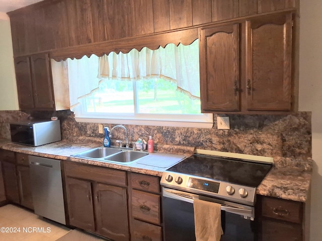 kitchen with appliances with stainless steel finishes, backsplash, and a sink