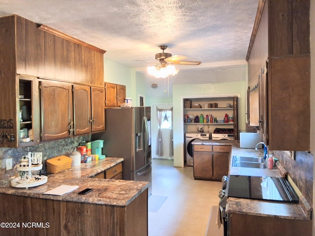 kitchen with electric range oven, a peninsula, a textured ceiling, light floors, and a sink