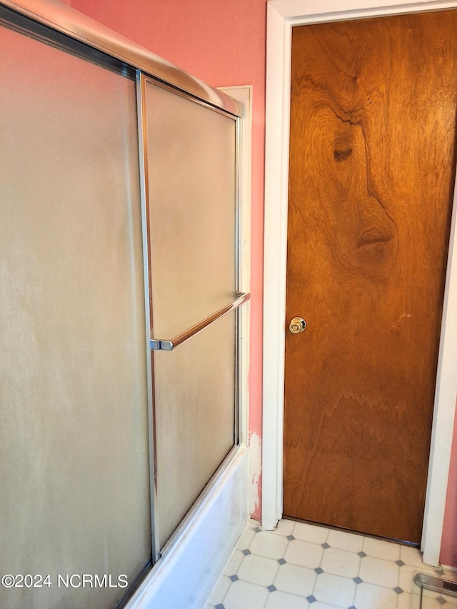 bathroom featuring bath / shower combo with glass door and tile patterned floors