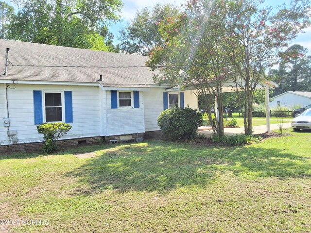 view of property exterior with crawl space, a shingled roof, and a lawn