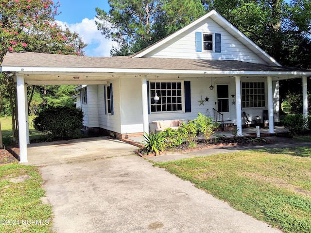 bungalow-style house featuring a carport, roof with shingles, driveway, and a front lawn