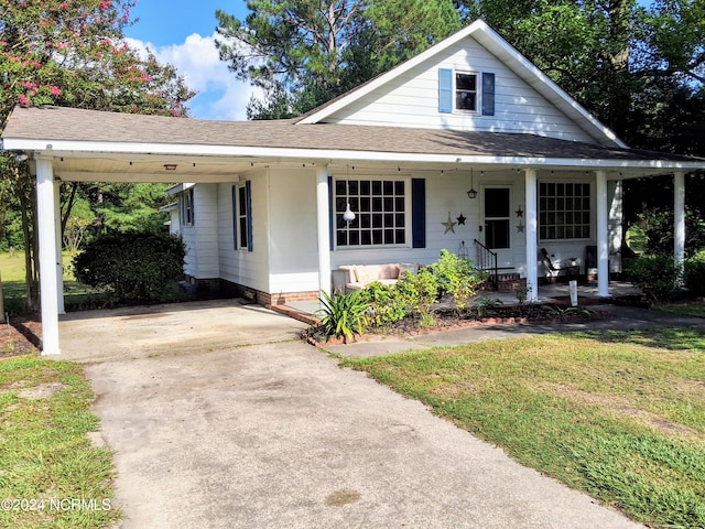 bungalow with a carport, concrete driveway, roof with shingles, and a front lawn