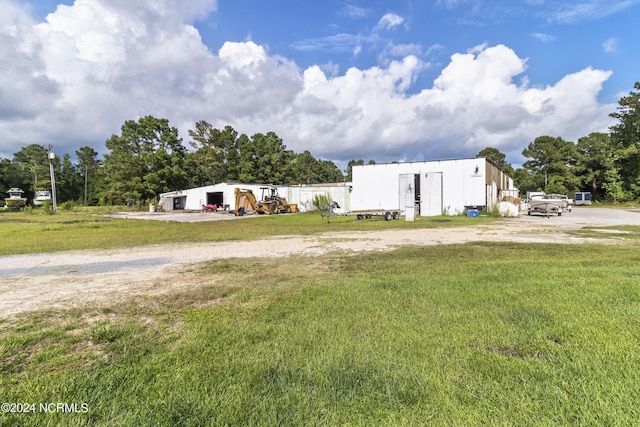 view of front facade with a pole building, a front lawn, and an outdoor structure