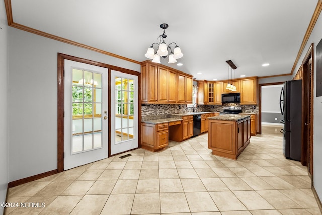 kitchen featuring decorative light fixtures, crown molding, black appliances, light stone countertops, and a center island