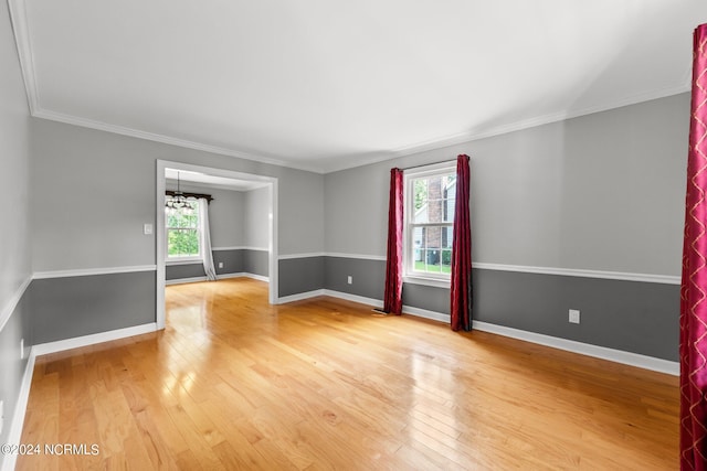 spare room featuring crown molding, a chandelier, and wood-type flooring