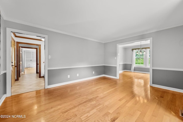 empty room featuring ornamental molding, a chandelier, and light tile patterned floors