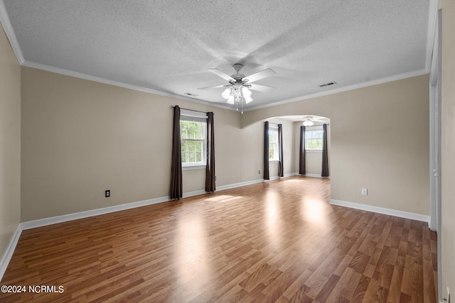 empty room featuring a textured ceiling, ceiling fan, ornamental molding, and wood-type flooring