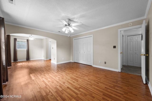 unfurnished bedroom with light hardwood / wood-style floors, crown molding, ceiling fan, and a textured ceiling