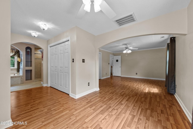 entrance foyer featuring a textured ceiling, light hardwood / wood-style flooring, ceiling fan, and ornamental molding