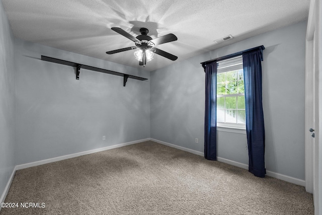 carpeted spare room featuring a textured ceiling and ceiling fan