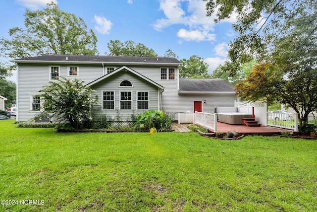 rear view of property with a wooden deck and a lawn