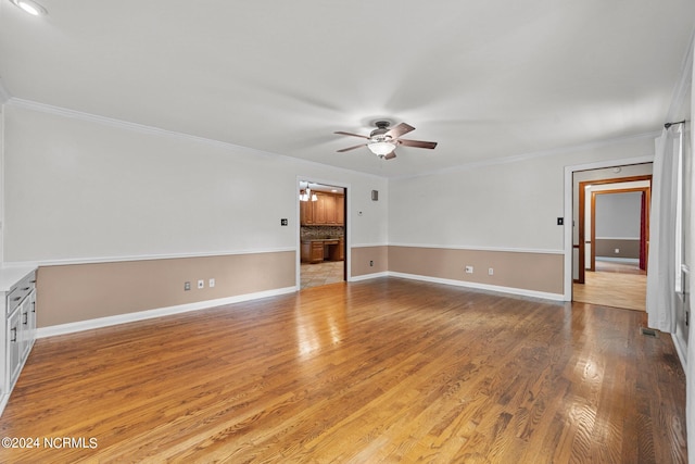 empty room with ceiling fan, crown molding, and light wood-type flooring