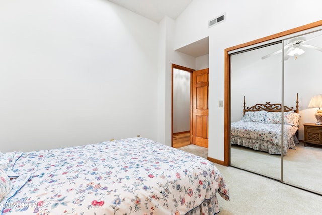 carpeted bedroom featuring a closet and high vaulted ceiling