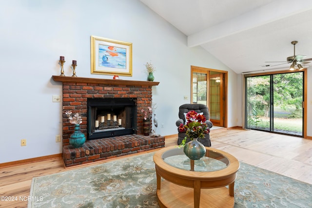 living room featuring wood-type flooring, a fireplace, lofted ceiling with beams, and ceiling fan