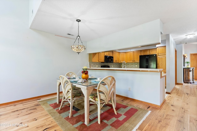 dining space with light hardwood / wood-style flooring and sink