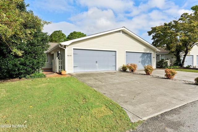 ranch-style home with a garage and a front lawn