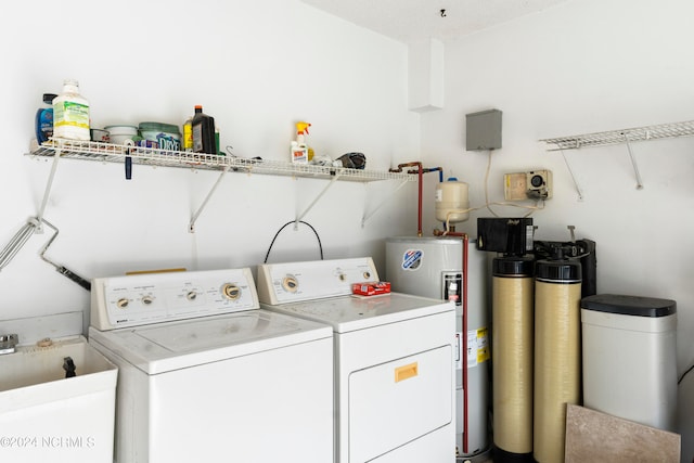 laundry room with water heater and washer and clothes dryer