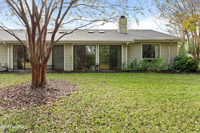 back of property featuring a lawn