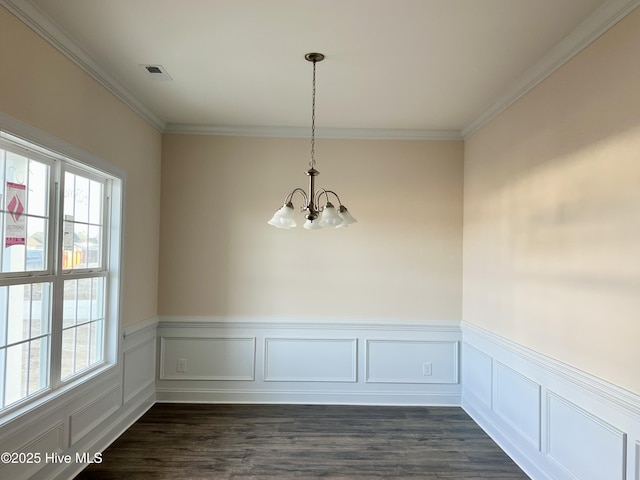 unfurnished dining area with ornamental molding, dark hardwood / wood-style flooring, and a notable chandelier