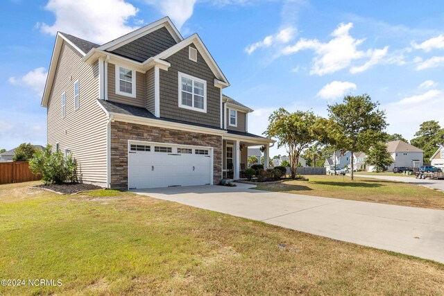 craftsman inspired home with a garage and a front lawn