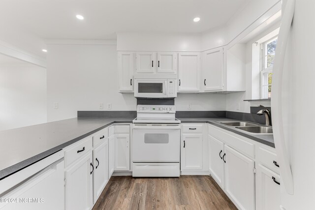 kitchen with white cabinetry, ornamental molding, sink, wood-type flooring, and white appliances