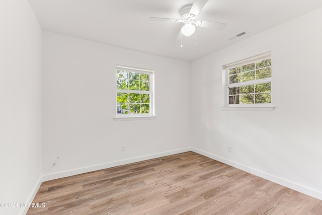 spare room featuring light wood-style flooring, visible vents, baseboards, and a ceiling fan