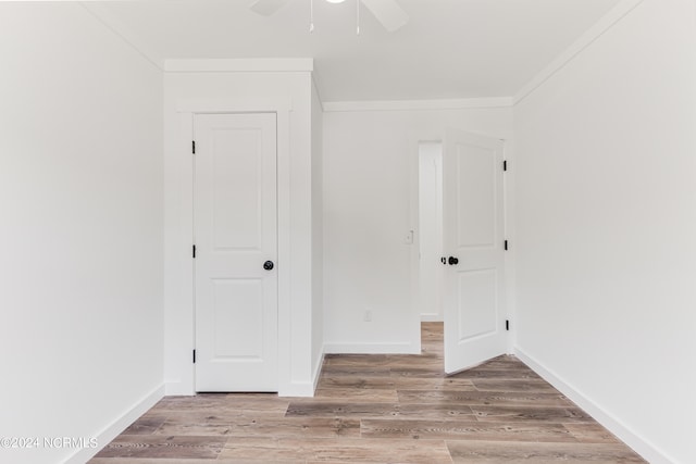 unfurnished bedroom with ceiling fan, crown molding, and wood-type flooring