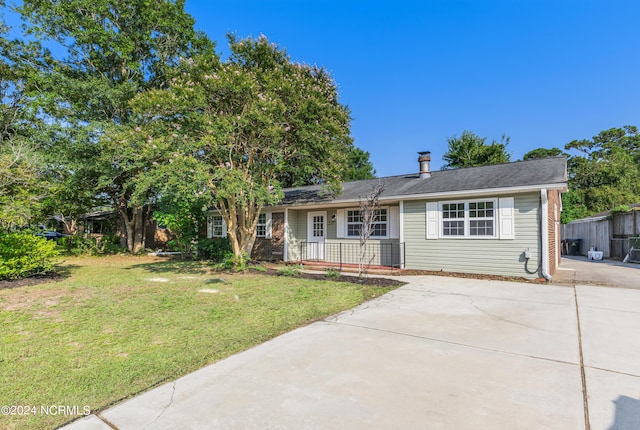 single story home featuring concrete driveway and a front yard