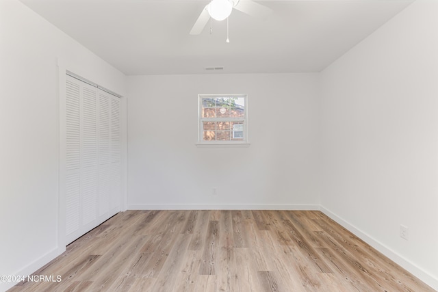 unfurnished bedroom featuring a ceiling fan, visible vents, baseboards, a closet, and light wood finished floors