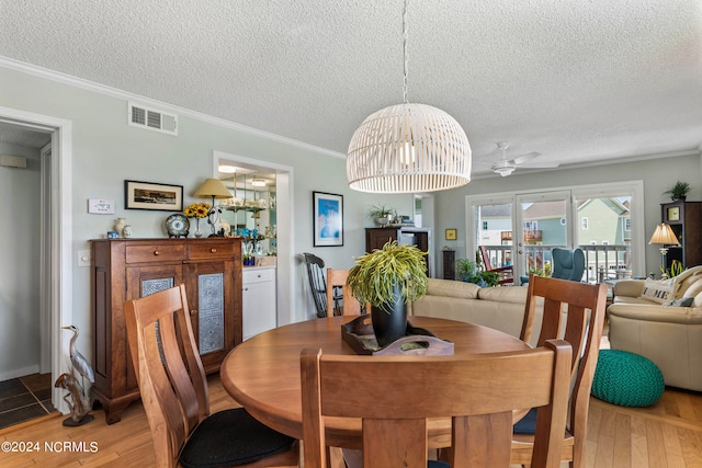 dining area with a textured ceiling, hardwood / wood-style flooring, and ceiling fan