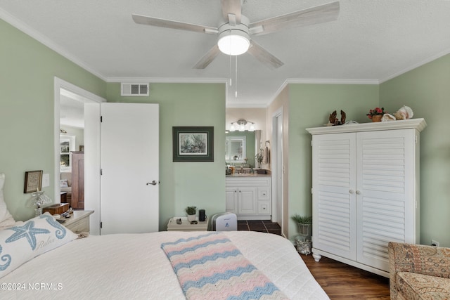 bedroom with dark wood-type flooring, ceiling fan, connected bathroom, and crown molding