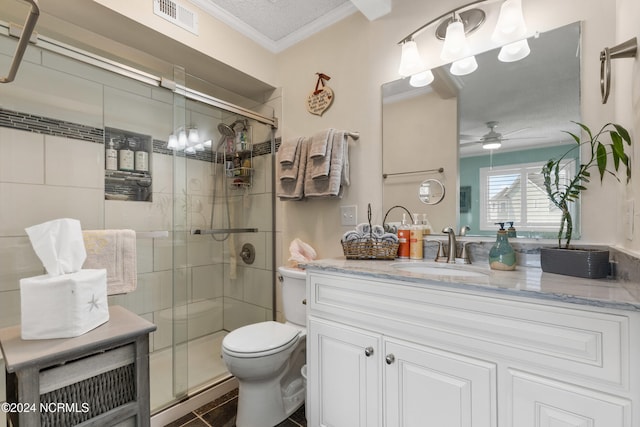 bathroom with toilet, vanity, a textured ceiling, ceiling fan, and a shower with shower door