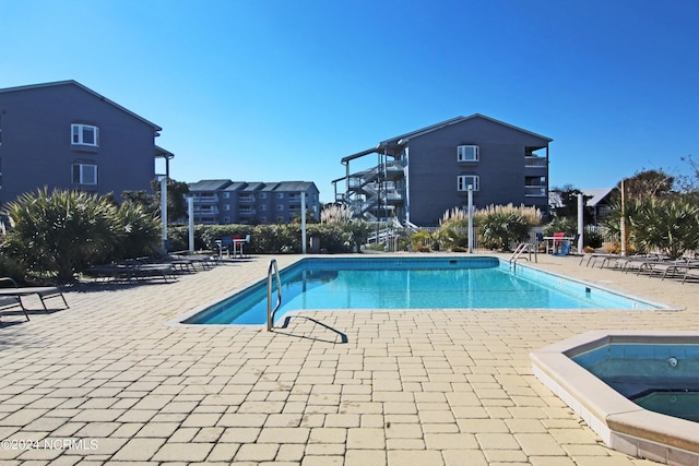 community pool with a community hot tub and a patio area