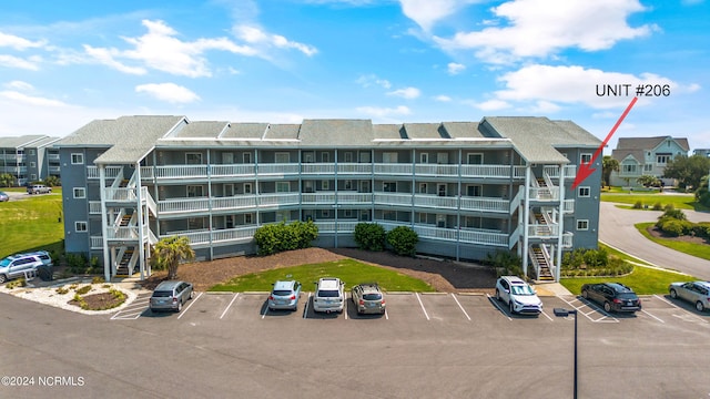 view of building exterior with uncovered parking and a residential view