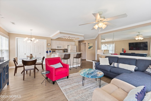 living room with light hardwood / wood-style floors, ceiling fan with notable chandelier, and ornamental molding