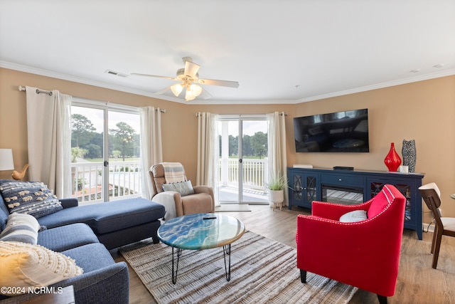 living room featuring ceiling fan, plenty of natural light, light hardwood / wood-style flooring, and crown molding