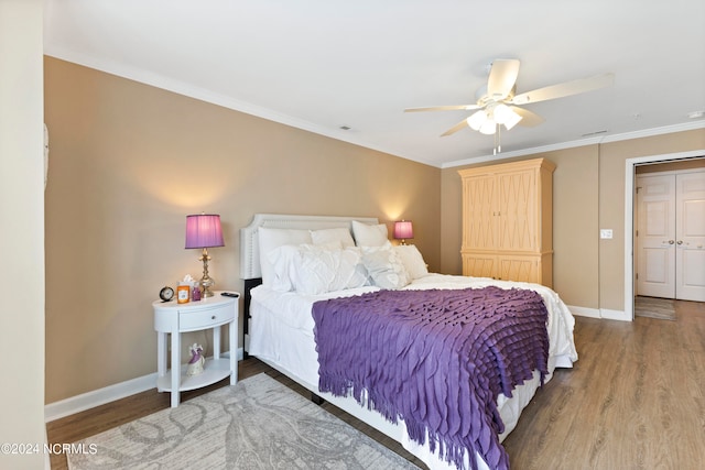 bedroom with ceiling fan, ornamental molding, a closet, and wood-type flooring