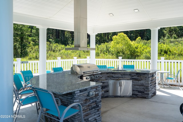 view of patio with area for grilling, an outdoor bar, and grilling area