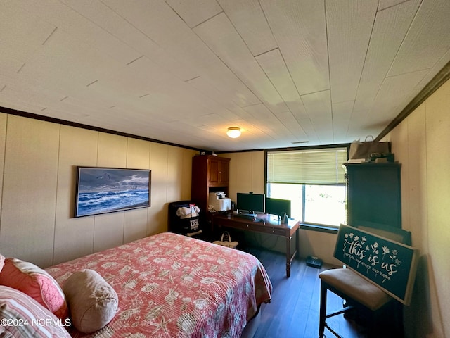 bedroom featuring wood walls, crown molding, and hardwood / wood-style flooring