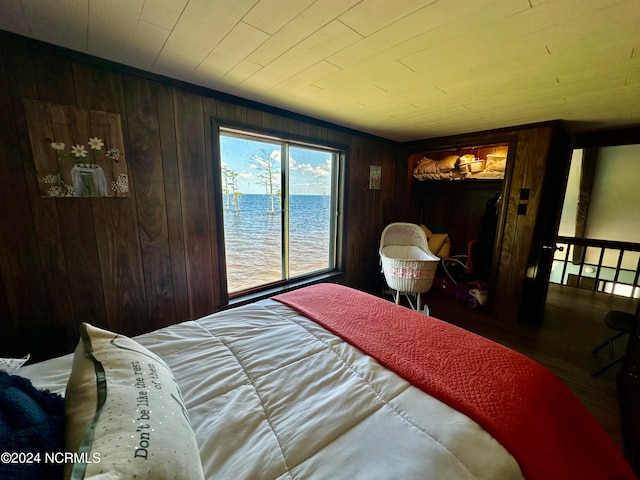 bedroom featuring a water view and wooden walls