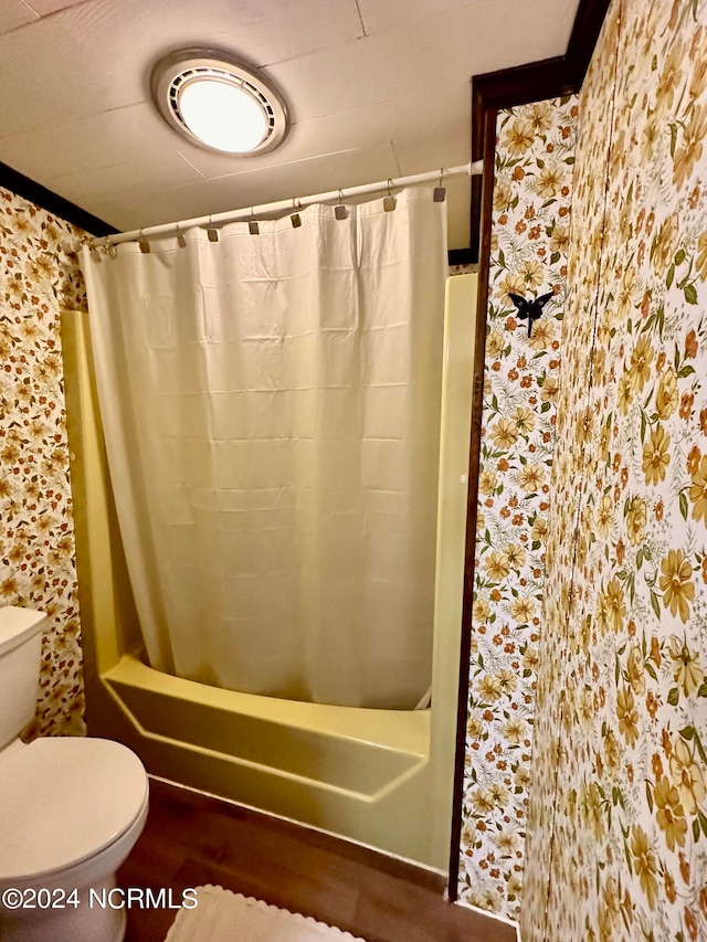 bathroom with ornamental molding, shower / bath combination with curtain, and toilet