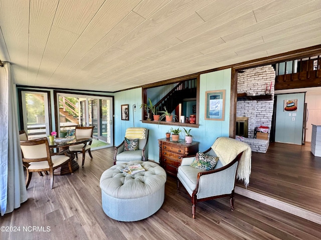 sitting room with wood walls, wooden ceiling, and hardwood / wood-style flooring